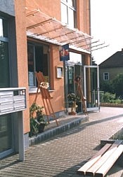 Gebäudefassade mit Glasfronten und überdachter Terrasse