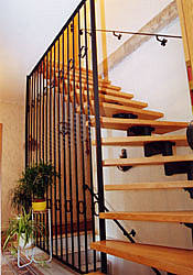 Treppe aus Holz mit modernem Geländer aus vertikalen Metallstäben