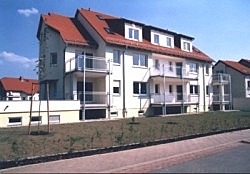 Wohngebäude mit roten Ziegeldächern und Metallbalkonen
